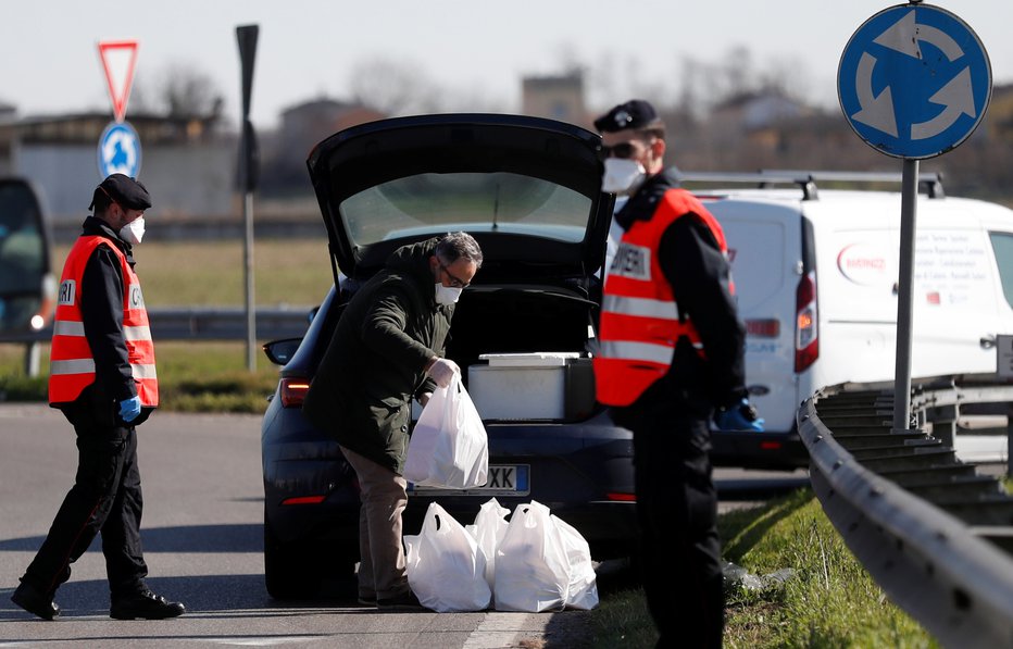 Fotografija: V Italiji je devet regij v popolni izolaciji, na ulicah karabinjerji nosijo zaščitne maske. FOTO: Reuters