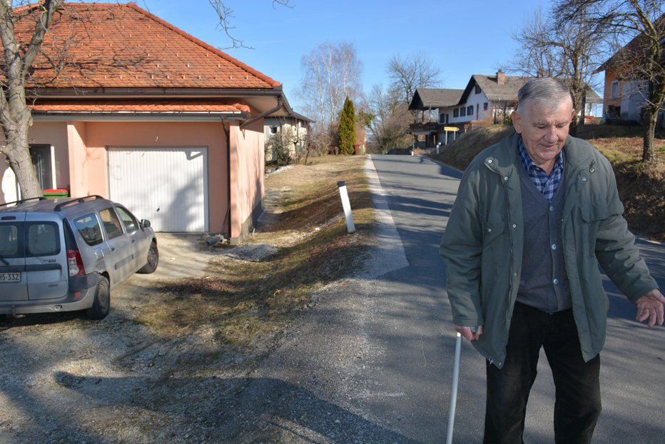 Fotografija: Z berglo si pomaga pri sprehodu ob prometni javni cesti, ki teče, kot pravi, po njegovem.