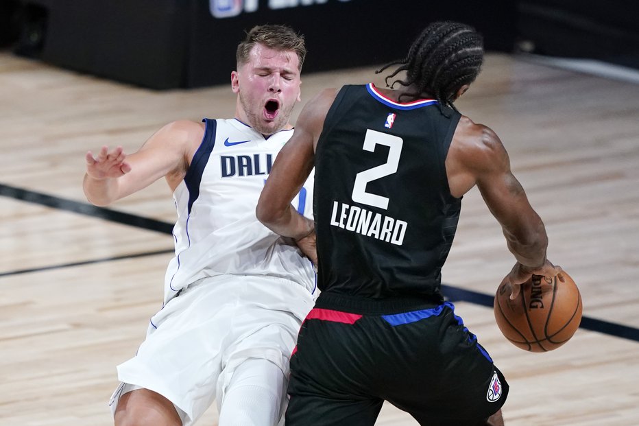 Fotografija: Luka Dončić se je le za hip pustil položiti na pleča Kawhiju Leonardu. FOTO: Ashley Landis/USA Today Sports