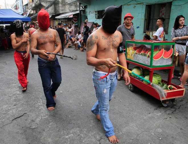 Katoliški gorečneži na Filipinih si na veliki petek bičajo svoje hrbte, skrajneži pa se dajo celo za nekaj minut pribiti na križ. Foto Reuters