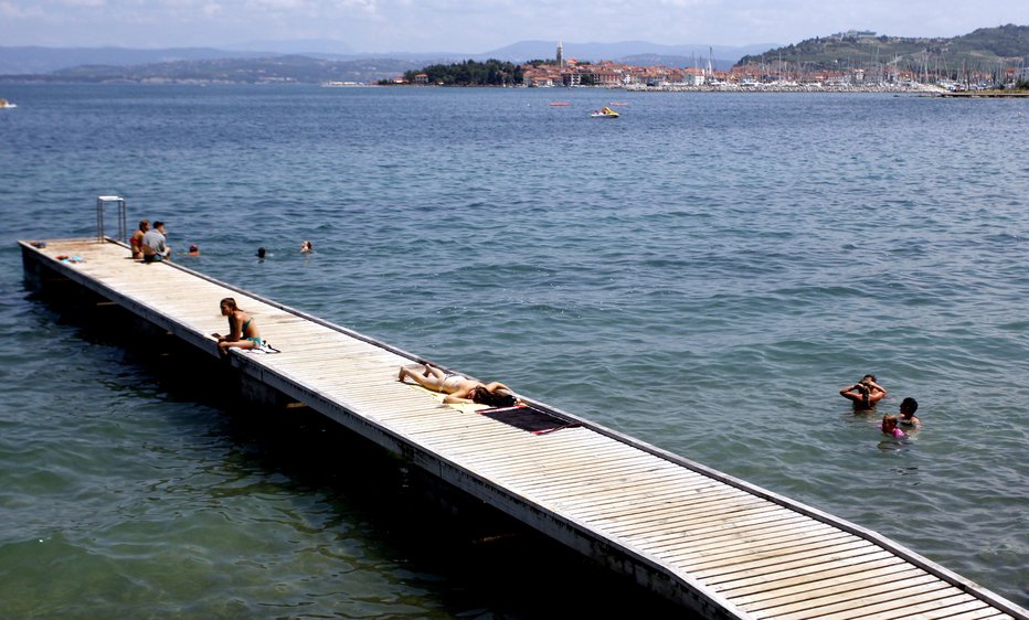 Fotografija: Na plaži pri Svetilniku v Izoli so kopalci včeraj iz morja potegnili utopljenca. FOTO: Roman Šipić, Delo