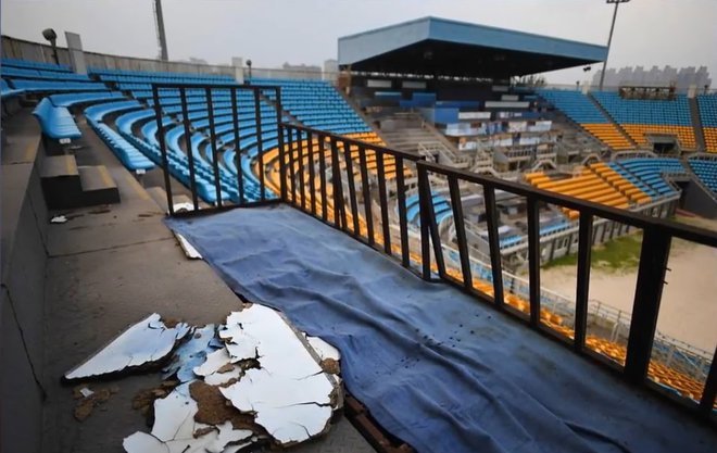 Nekateri sedeži stadiona, zgrajenega za odbojko na mivki, gnijejo. FOTO: Youtube