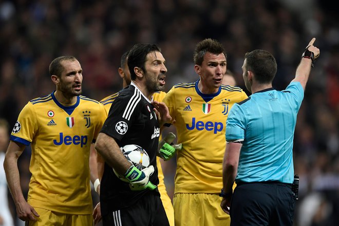 Sodnik Michael Oliver je Gianluigiju Buffonu pokazal pot v slačilnico, ob vratarju Juventusa sta protestirala Giorgio Chiellini in Mario Mandžukić. Foto: AFP