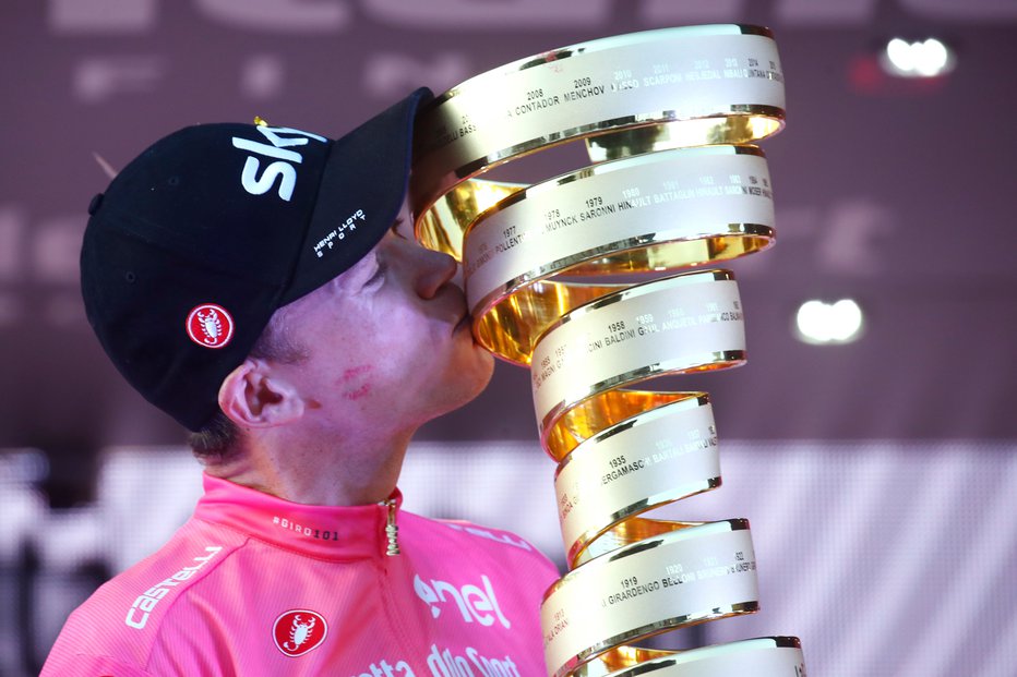 Fotografija: Chris Froome ima na licu ostanke ličila po poljubu hostese, sam pa poljublja pokal za zmago na Giru. FOTO: Afp