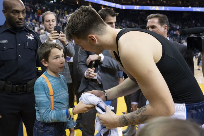 Luka Dončić se je mlademu navijaču oddolžil s podpisanim dresom. FOTO: Reuters