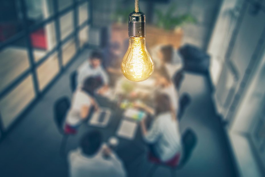 Fotografija: Young business people are discussing together a new startup project. A glowing light bulb as a new idea. FOTO: Scyther5 Getty Images/istockphoto