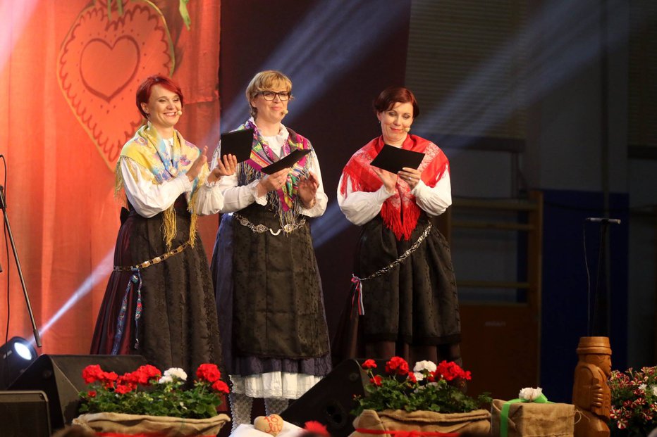 Fotografija: Večer viž v narečju so povezovale (z leve): Damjana Peternelj, Andreja Čamernik in Jana Jenko, vedno v narodni noši. Foto: Radio Sora