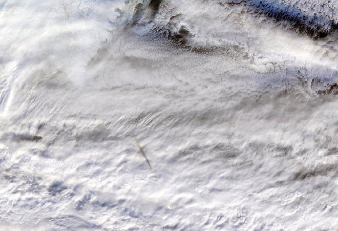 Dobro je videti ognjeno kroglo in temno dimno sled, ki izstopa nad belim oblakom. FOTO: Nasa