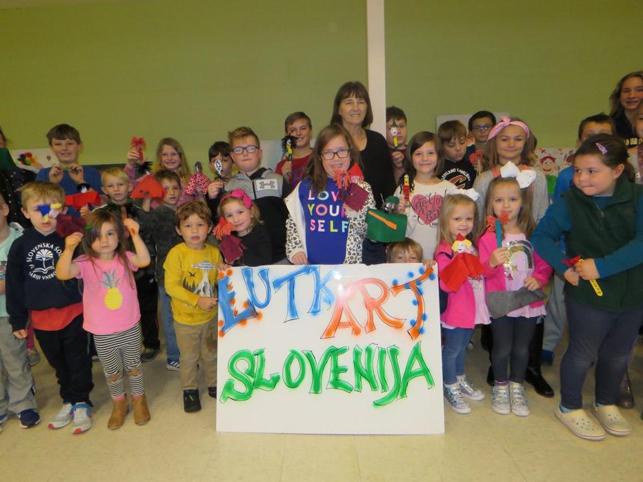 Fotografija: Gostiteljica Marija Sedmak s svojimi učenci slovenske šole v Clevelandu na odprtju likovne razstave Lutkar