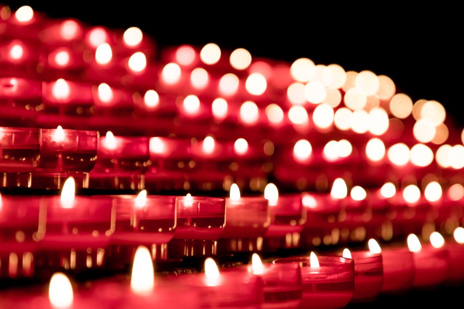 Fotografija: Candlelight fire flames in rows are silent religion symbol for peace, life and soul. Obituary hope sacrifice against sorrows and pain.