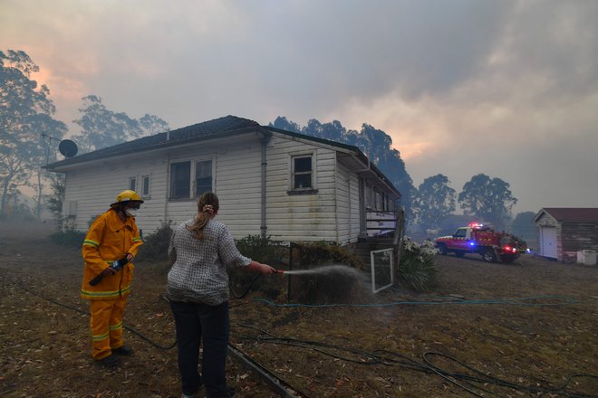 Gasilci poskušajo rešiti hiše. FOTO: Saeed Khan/Afp