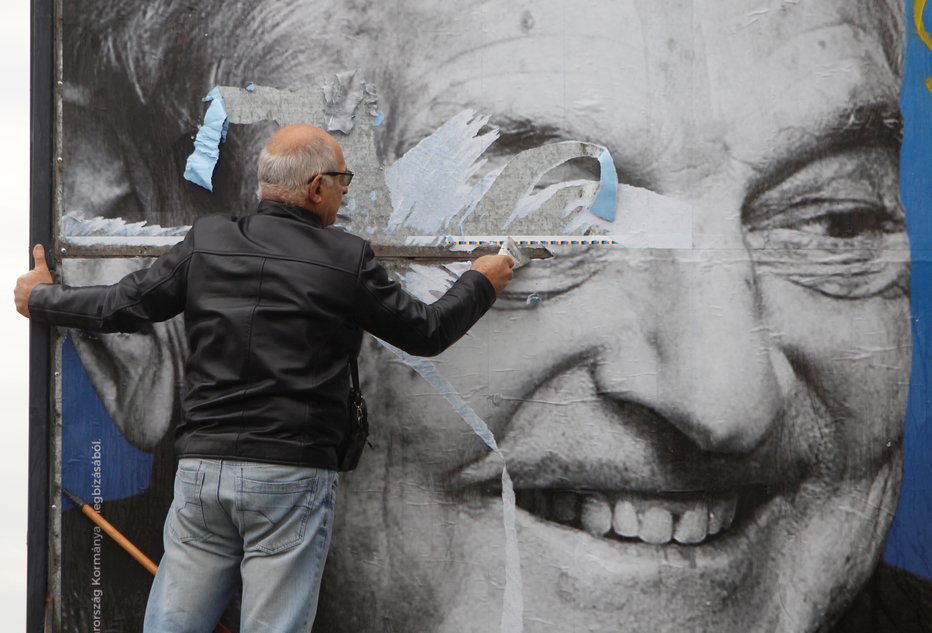 Fotografija: Activists of Egyutt (Together) opposition party removes a government billboard displaying George Soros in monochrome next to a message urning Hungarians to take part in a national consultation about what it calls a plan by the Hungarian-born financier to settle a million migrants in Europe per year, in Budapest, Hungary, October 5, 2017. REUTERS/Bernadett Szabo - RC150C929800