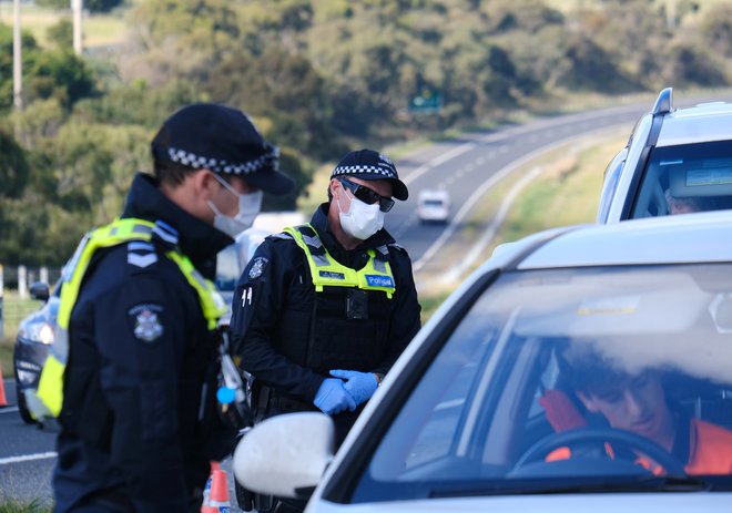 Osebje policije izvaja nadzor nad spoštovanjem stroge karantene v zvezni državi Victorija. FOTO: Stringer Via Reuters