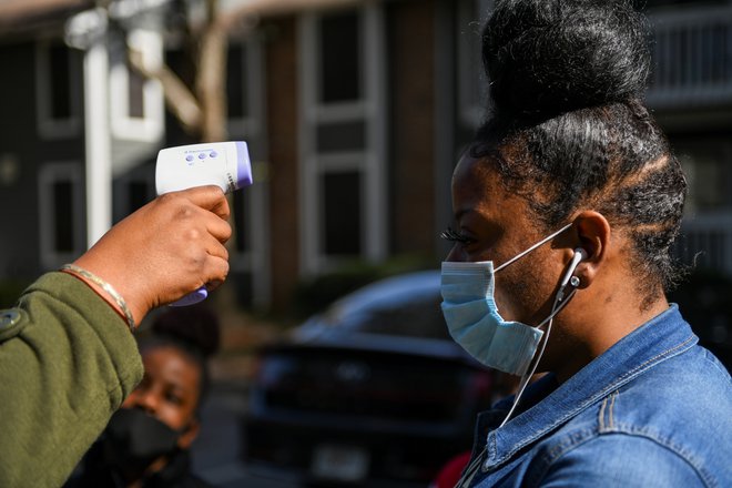 Prebivalcem so pred vstopom na avtobus izmerili temperaturo. FOTO: Brandon Bell/Reuters