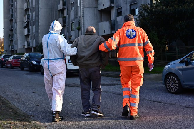 Prostovoljci v Italiji pomagajo ostarelim. FOTO: Miguel Medina/AFP