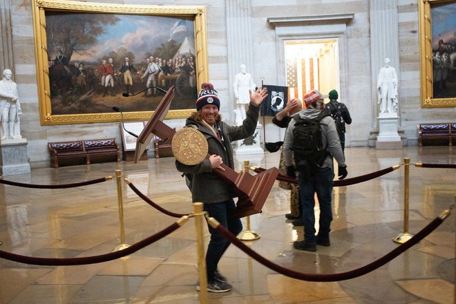 Trumpov privrženec odnaša govorniški oder predsednice spodnjega doma kongresa med nedavim vdorom v Kapitol. FOTO: WIN MCNOMEE/GETTY IMAGES