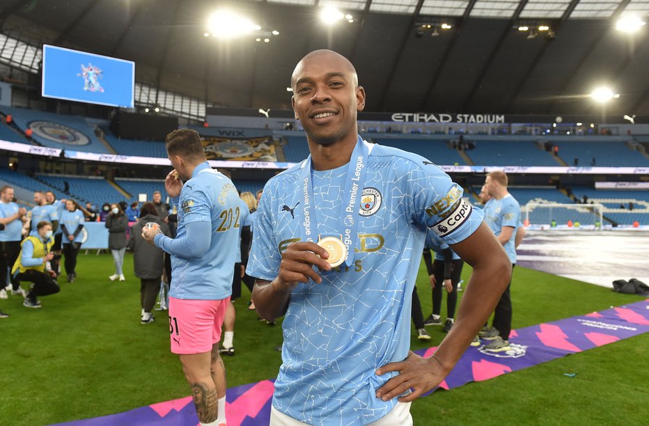 Fotografija: Fernandinho je takole v nedeljo poziral z zlato kolajno za novi naslov angleškega prvaka. FOTO: Peter Powell/Reuters