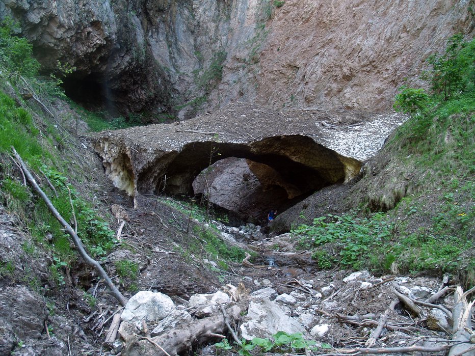 Fotografija: Po letošnji obilni zimi je v kotlu, kamor pada Curk, ostal orjaški snežni most. FOTOGRAFIJI: Janez Mihovec