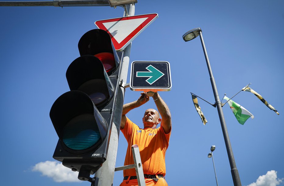 Fotografija: Črn znak z zeleno puščico stoji. FOTOGRAFIJE: Jože Suhadolnik