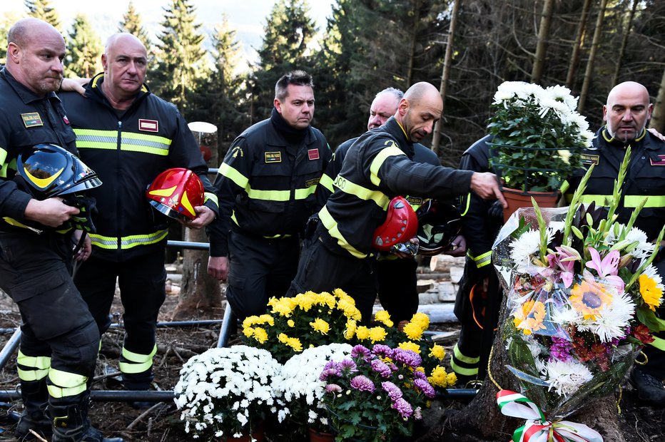 Fotografija: Gasilci so se po zahtevnem odstranjevanju razbitin poklonili žrtvam tragedije. FOTO: Flavio Lo Scalzo/Reuters
