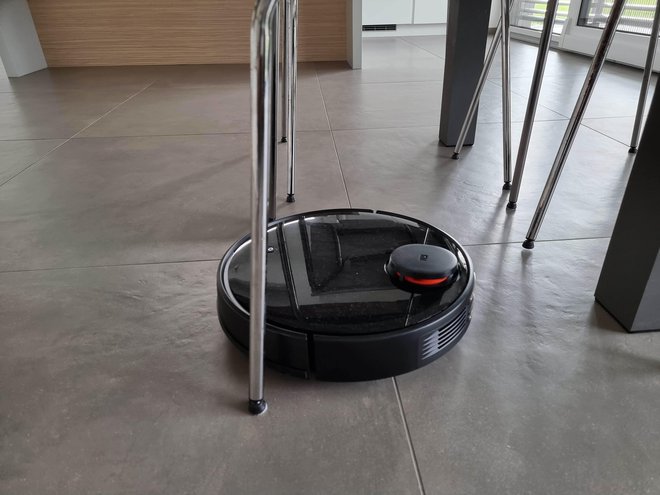 Robotski sesalnik xiaomi mi robot vacuum-mop P se je odlično znašel med nogami mize in stolov. FOTOGRAFIJE: Staš Ivanc
