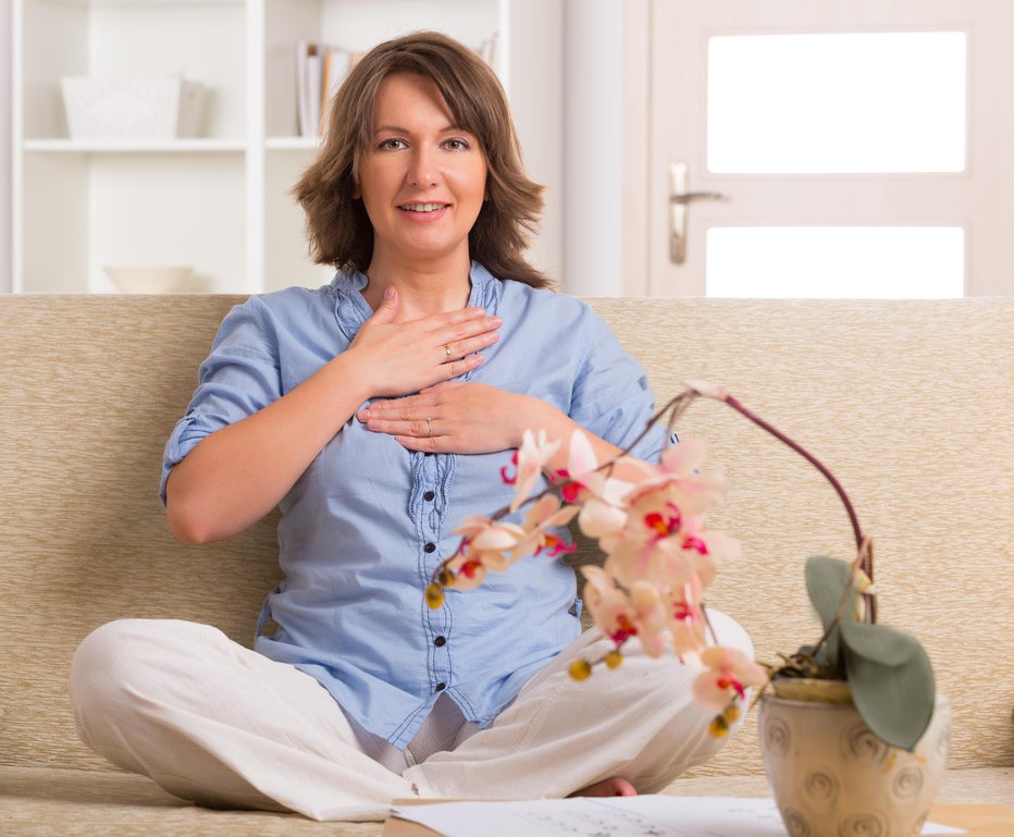 Fotografija: Woman practicing self Reiki transfering energy through palms, a kind of energy medicine.