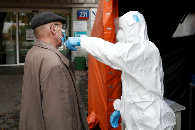 Merjenje temperature pred bolnišnico v Varšavi. FOTO: Kacper Pempel/Reuters