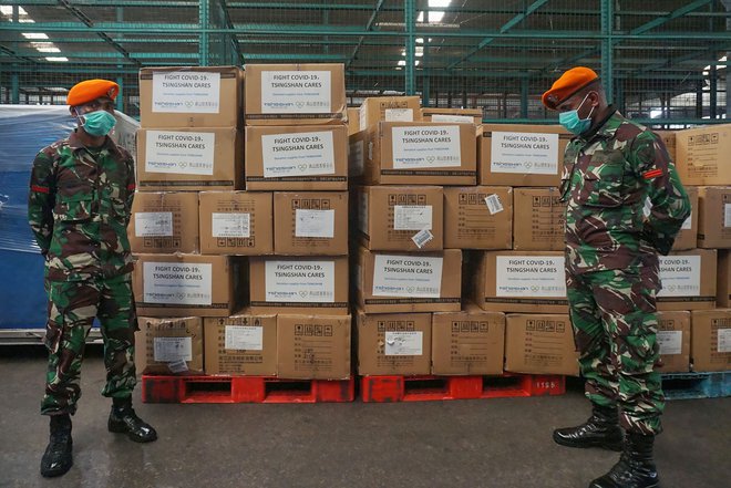 Dva vojaka ob prispelih paketih medicinske opreme za pomoč pri boju proti novemu koronavirusu. FOTO: Fajrin Raharjo/AFP