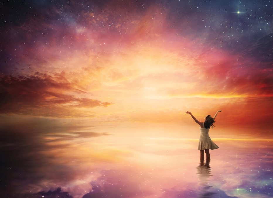 Fotografija: Woman stands in praise before a beautiful night sky.