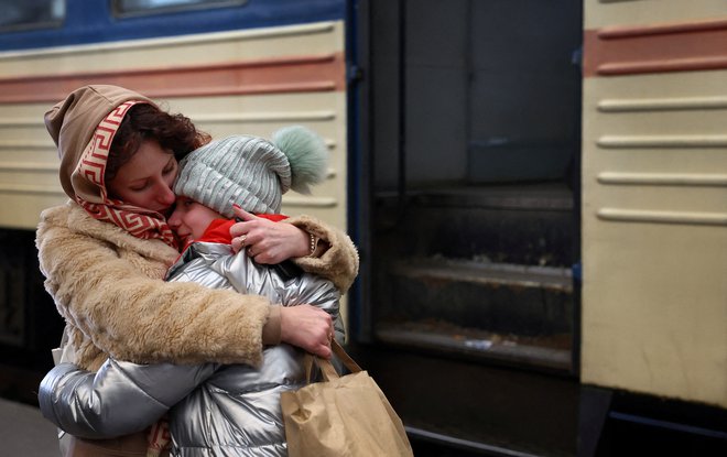 Mati drži svojo jokajočo hčer po prihodu z vlakom iz Harkova v Lvov. FOTO: Kai Pfaffenbach/Reuters
