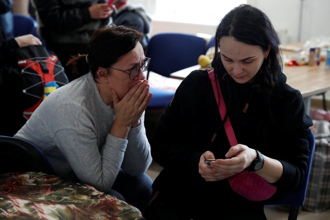 Ukrajinki poslušata govor predsednika Volodomirja Zelenskega. FOTO: Bernadett Szabo/Reuters
