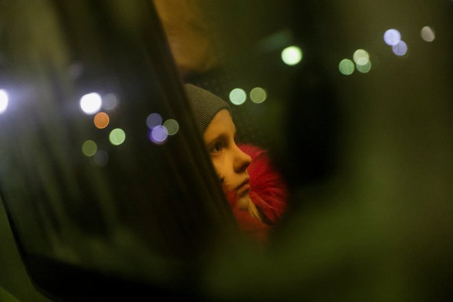 Ukrajinski begunec sedi med potovanjem na vlaku proti Budimpešti po prehodu meje z Ukrajino. FOTO: Edgard Garrido/Reuters
