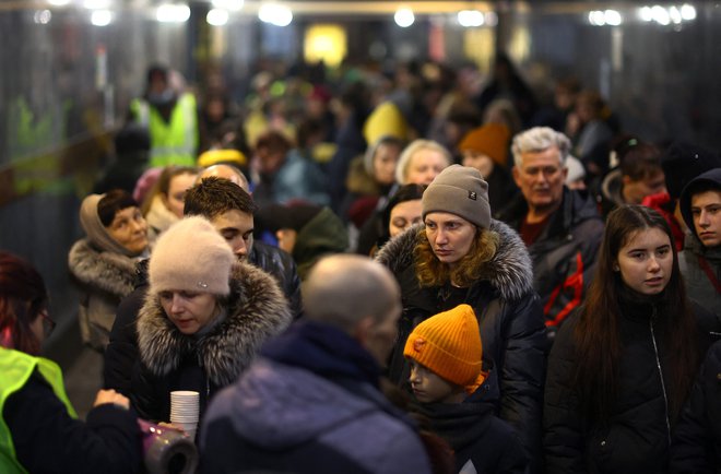 Begunci v čakalni vrsti za zadnji vlak dneva za Poljsko na glavni železniški postaji v Lvovu. FOTO: Kai Pfaffenbach/Reuters
