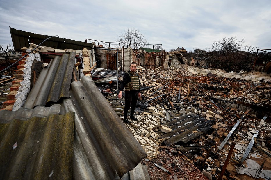 Fotografija: 32-letni humanitarni delavec Oleksandr Markov med ruševinami hiše svojih staršev v Černigovu. FOTO: Zohra Bensemra/Reuters
