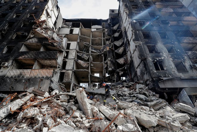 Reševalci med ruševinami v Mariupolju. FOTO: Alexander Ermochenko/Reuters
