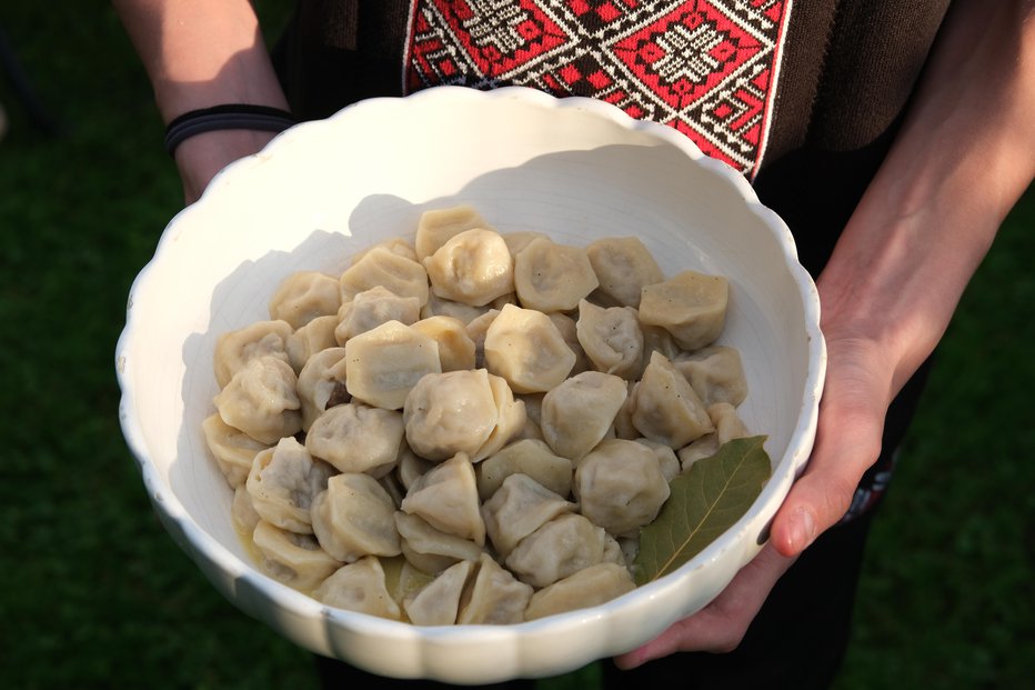 Fotografija: Na sredino vsakega kroga damo žličko nadeva, potem pa pelmene prepognemo v lunico (kot bi delali marmeladne žepke ali ajdove krape). FOTO: Špela Ankele
