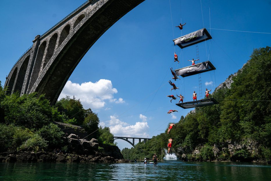 Fotografija: Navdušili so s skakanjem v vodo s kar treh trampolinov pod Solkanskim mostom.
