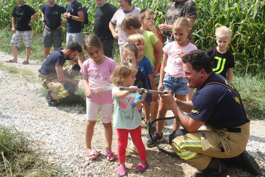 Fotografija: Gašenje ognja je pritegnilo otroke.
