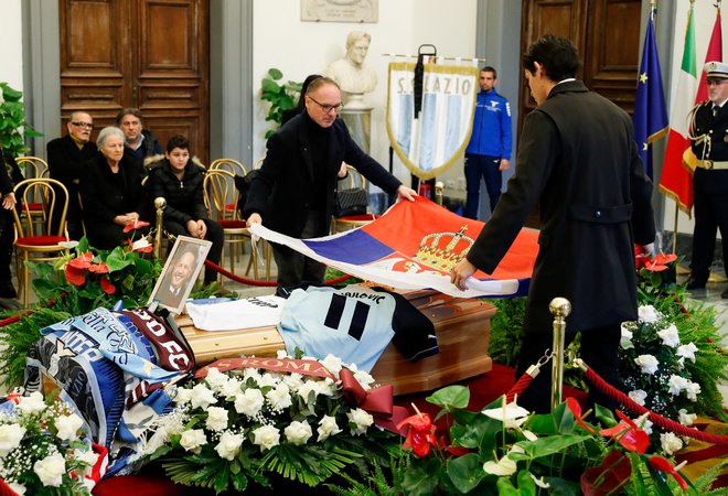 Prijatelj pokojnega Siniše je čez krsto položil srbsko zastavo. FOTO: Remo Casilli, Reuters
