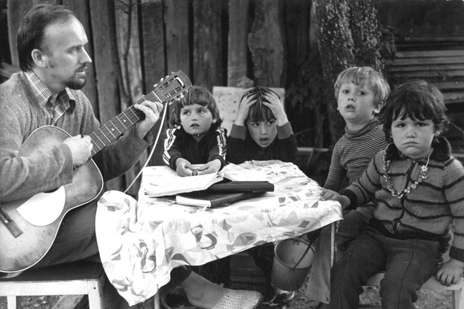 Skok s kitaro leta 1984 v Gabrijelah pri Krmelju, na mizi so obvezne, ročno napisane pesmarice. Foto: Zaim Šeremet
