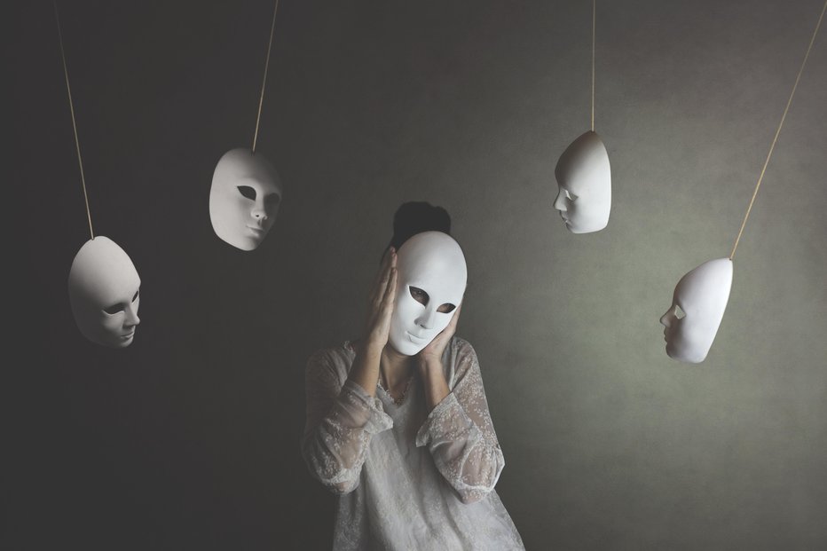 Fotografija: person with mask does not want to hear the judgment of other masks, concept of judgment and introspection
