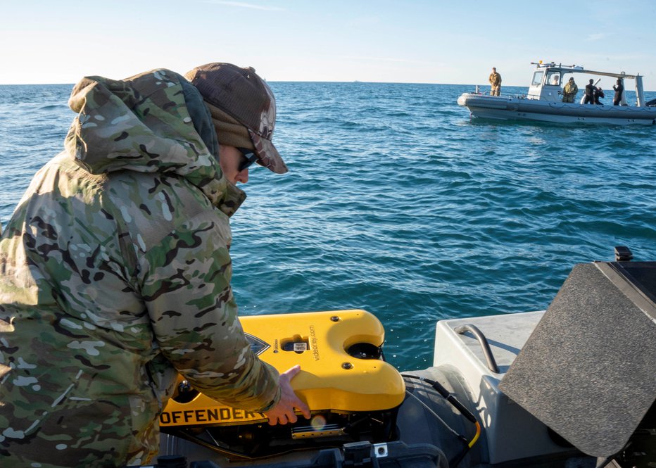 Fotografija: Mornar ameriške mornarice, dodeljen skupini za odstranjevanje eksplozivnih sredstev 2, išče ostanke balona s podvodnim vozilom. FOTO: US Navy, Reuters
