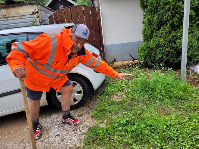 Cveto Perko nam pokaže, do kod je ponoči segala voda v Tržiču, a je k sreči do jutra odtekla. FOTO: Tina Horvat