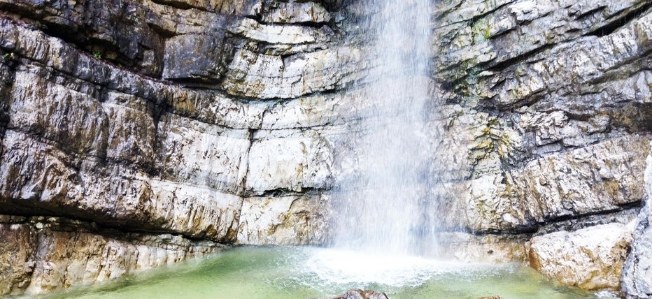 Fotografija: Nekdaj je bil v ustju slapu precej velik kamen, ki je tok vode razdelil na dva dela; spodaj sta se združila, od tod njegovo ime. FOTO: Janez Mihovec