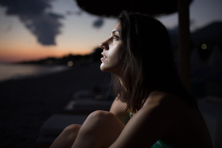 Fotografija: Woman watching the ocean,sea horizon with a Moon on the sky.Eclipse of the Moon.Eclipse of the sun.Stargazing,watching stars on the beach under the moonlight.Enjoying summer nights.Night sky.Sunrise FOTO: Eldinhoid Getty Images/istockphoto