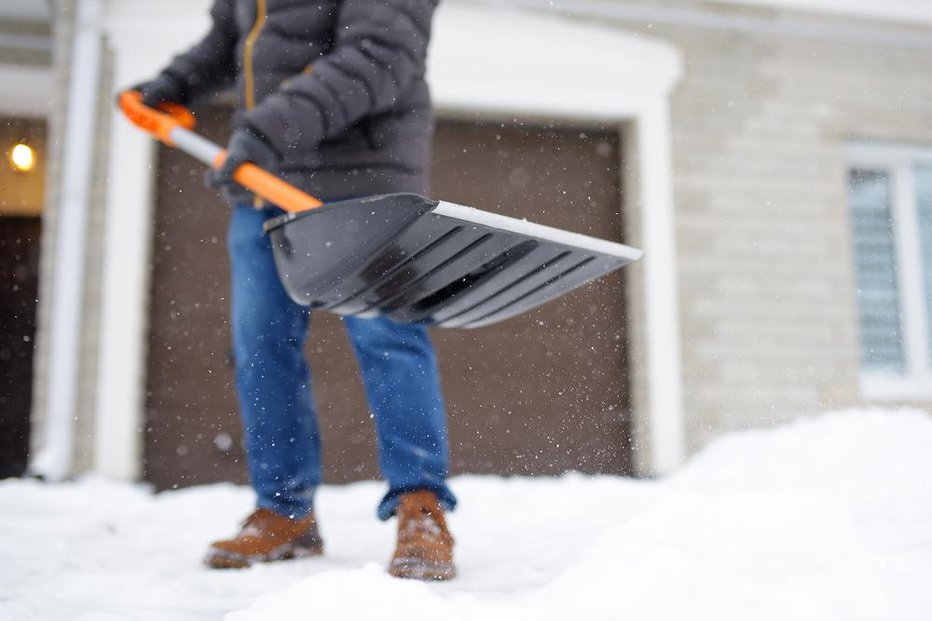 Fotografija: Tudi če se boste snega hoteli znebiti čim hitreje, na lopato ne nalagajte prevelike teže. FOTO: Maria Sbytova, Shutterstock