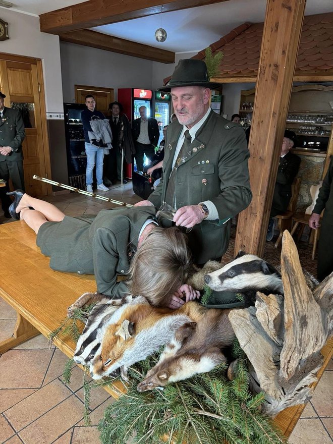 Krstitelj izlije nekaj kapljic vina zelencu za vrat in simbolno zamahne s palico. FOTO: Arhiv LD Šentilj