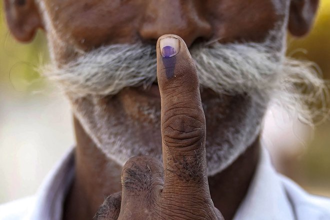 Tisti, ki je že volil, dobi označbo s črnilom, ki ga je nemogoče sprati vsaj štirinajst dni. FOTO: Himanshu Sharma/AFP
