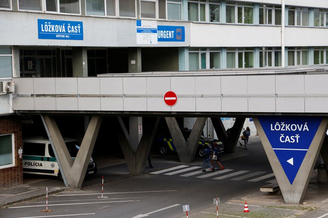 Policijska vozila, parkirana pred univerzitetno bolnišnico, kjer so operirali premierja. FOTO: Leonhard Foeger Reuters