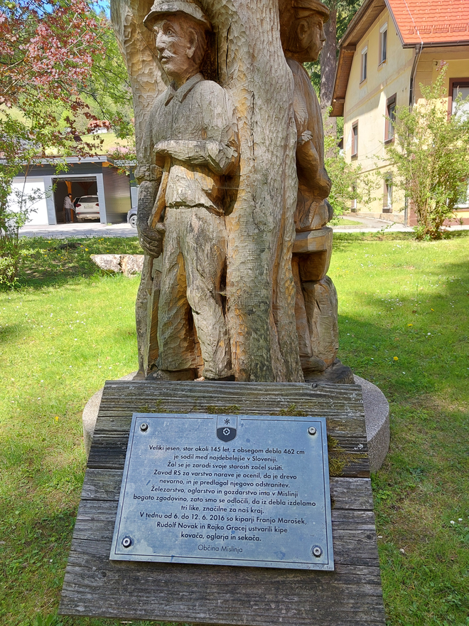 Gozdar, oglar in kovač (vsak na svoji strani skulpture), ki so jih izdelali iz 145 let starega jesena, varujejo pot. FOTO: Dejan Vodovnik